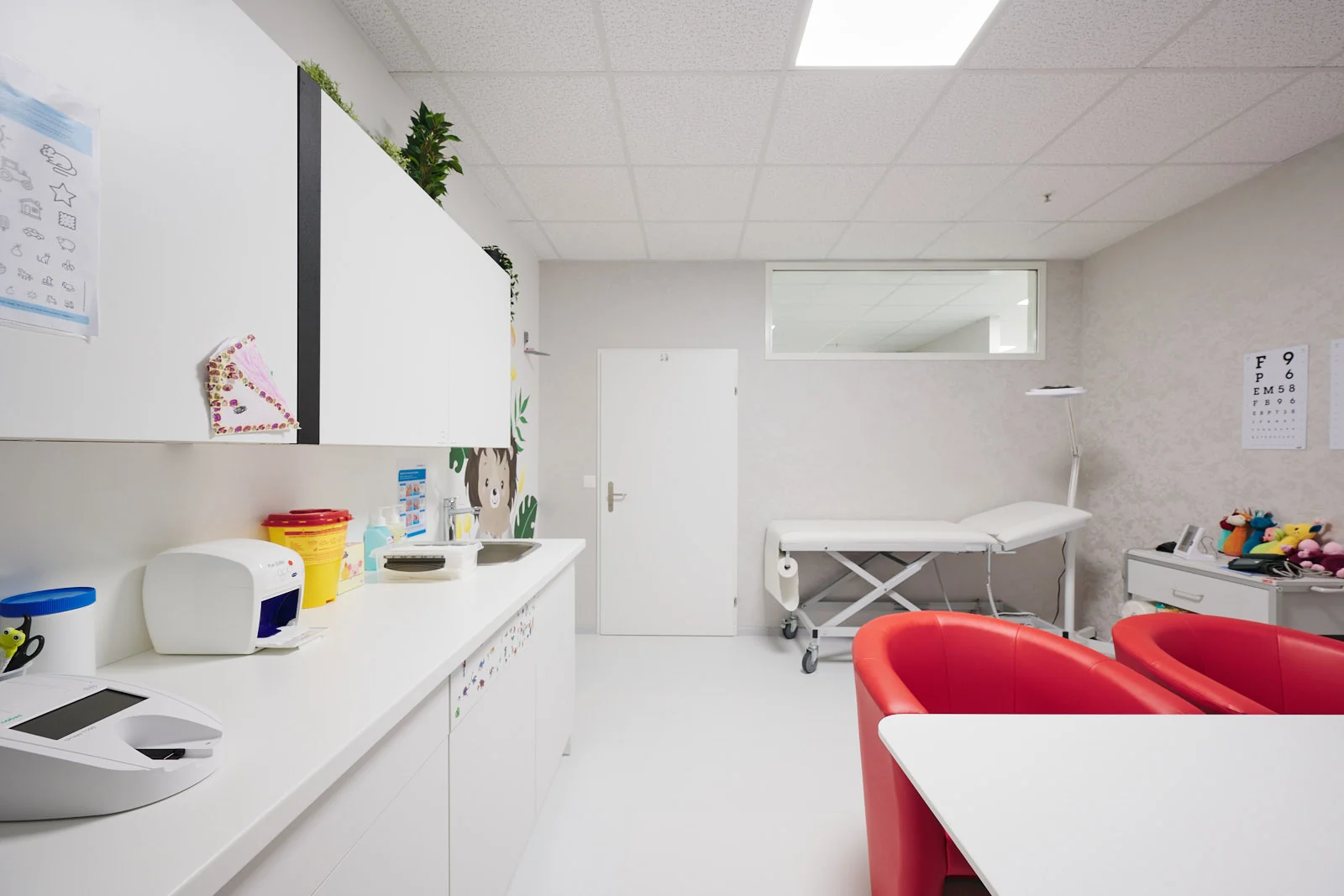 Helles Behandlungszimmer mit Praxislabor und kindgerechter Wandgestaltung – Kinderarztpraxis Chur West