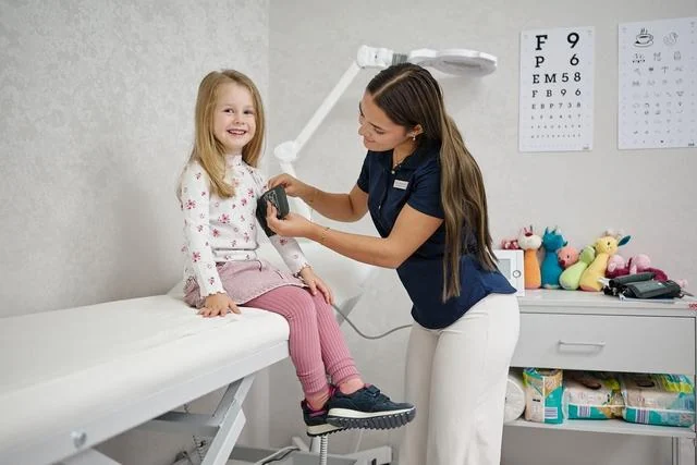 Ärztin untersucht ein Kind in der Kinderarztpraxis Chur West vor der Grippeimpfung
